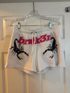 White Athletic Shorts with Pink Logo and Black Scorpion Graphic